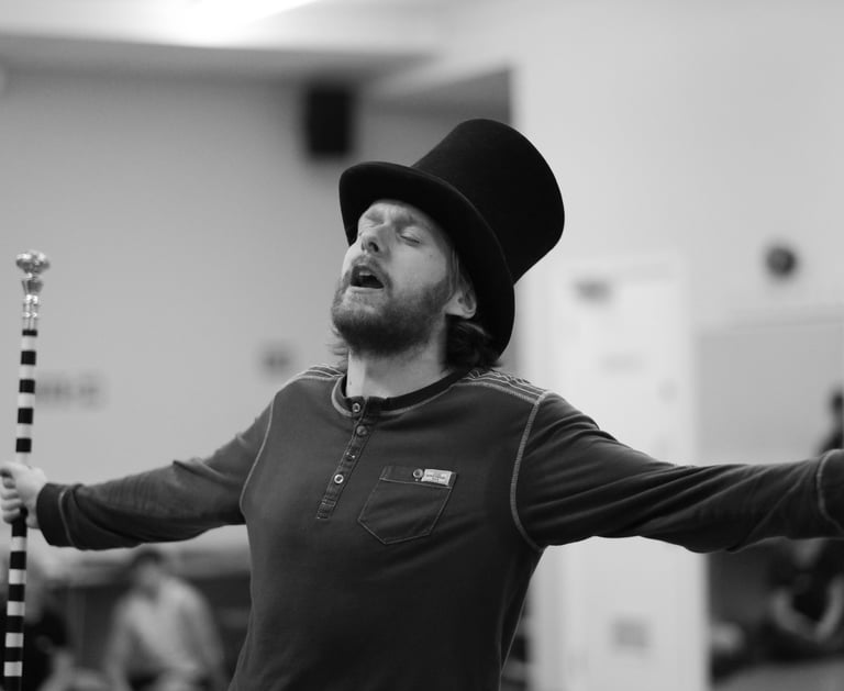 A man holding his arms out whilst singing