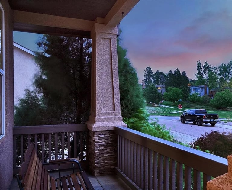 a bench on a porch with a bench and a car parked in front of it