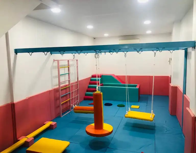 sebuah ruang sensori intergasi anak dengan ayunan perosotan dan kolam bola