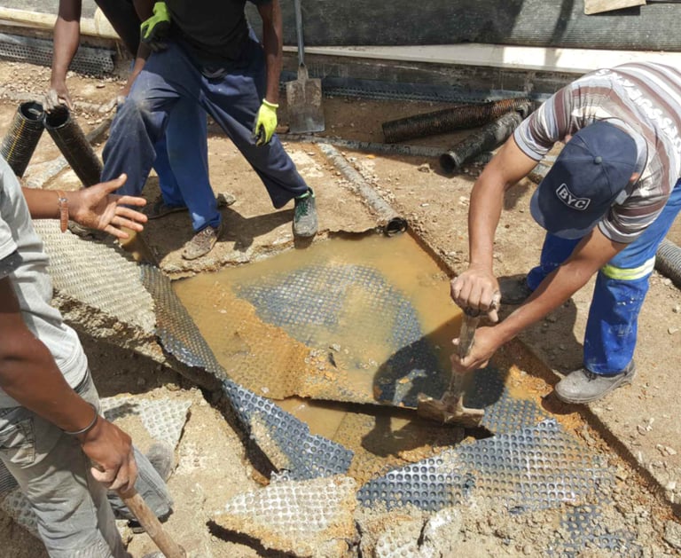 Engineers inspecting damaged concrete slab for water ingress