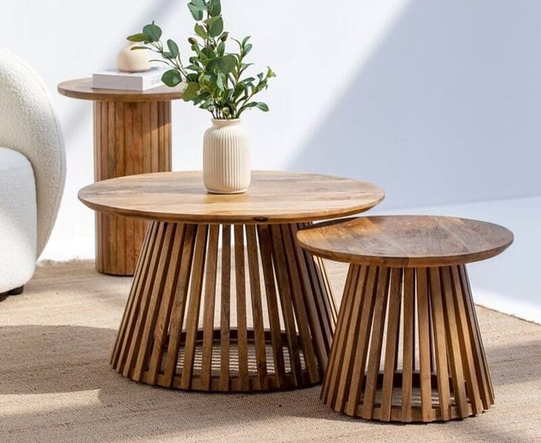 a set of tables with a plant in a room