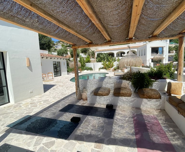 Private yoga studio in Benissa with mats, blocks, and props in outdoor pergola setting by pool