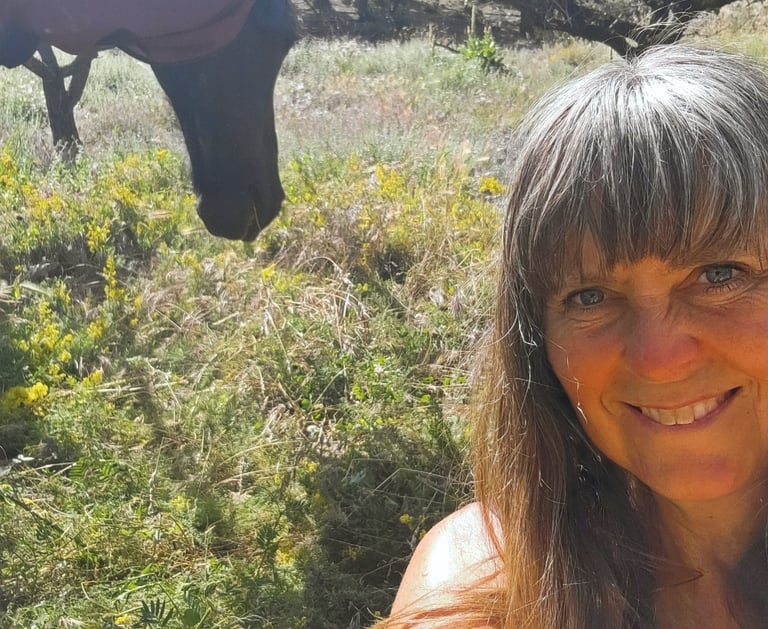 protrait of a woman and a black horse in a field