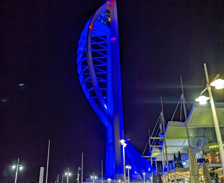 Spinnaker Tower lit up in blue against a dark night sky