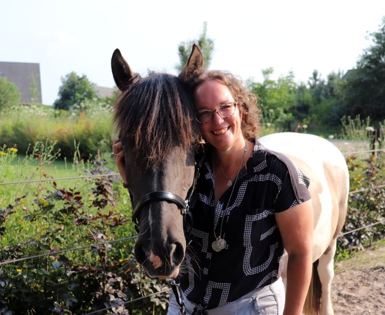 Claudia staat naast haar bruin witte paard