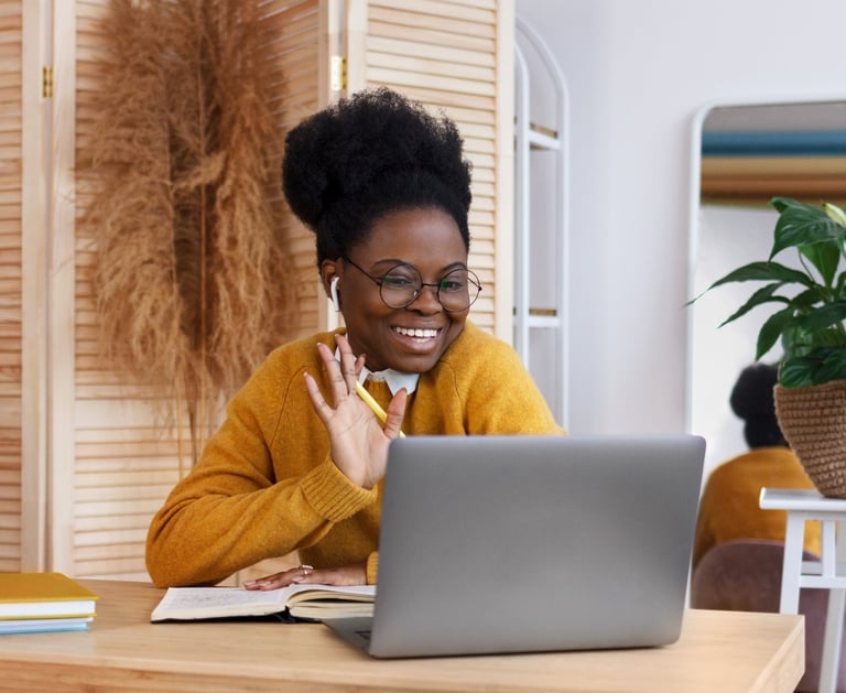 a woman sitting at a table with a laptop computer