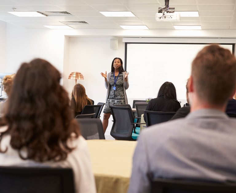 a woman in a business suit is standing in front of a presentation