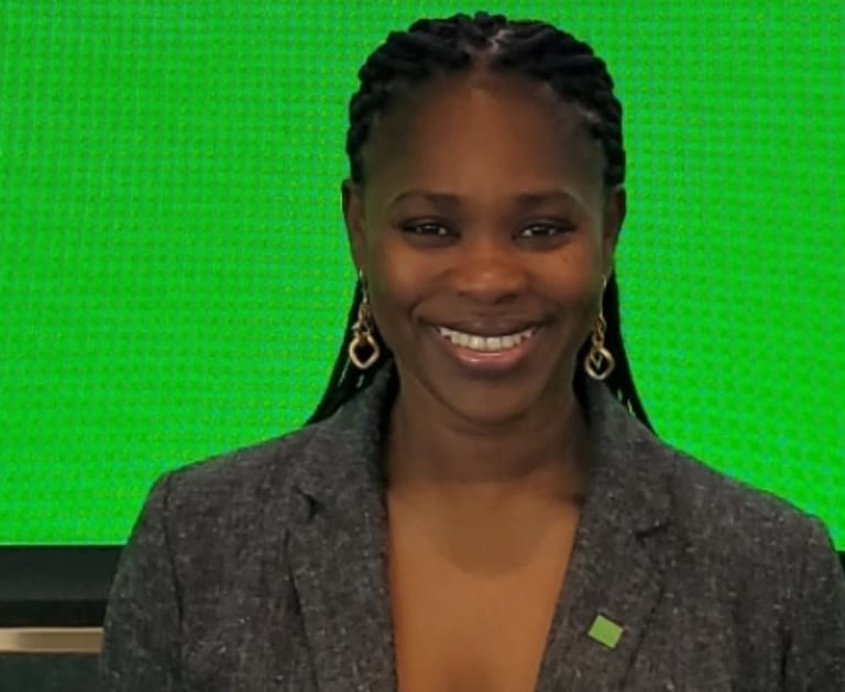 a woman in a gray jacket and earrings