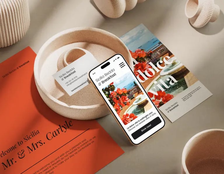 A stationary branding mockup featuring business cards, flyers, and a mobile phone for a B&B