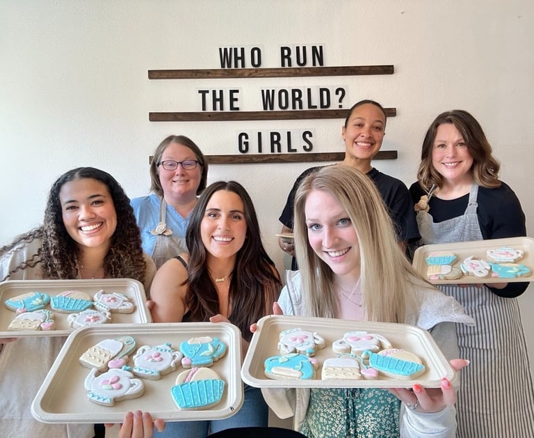 happy people holding their decorated cookies