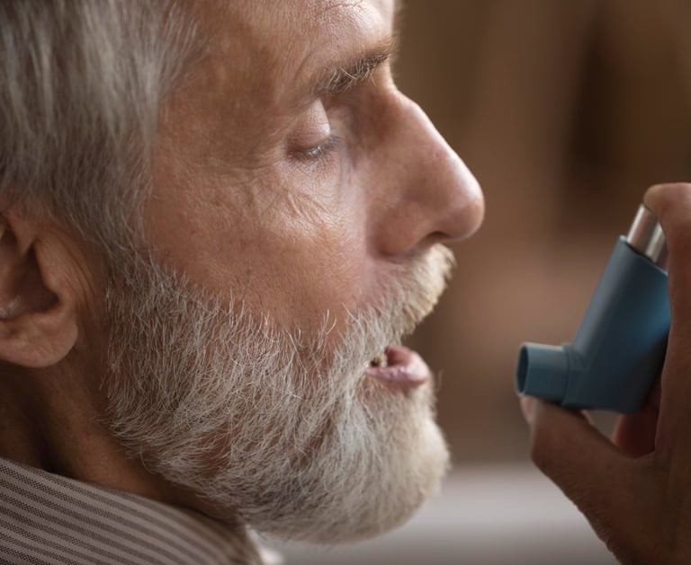 Hombre aplicándose un inhalador