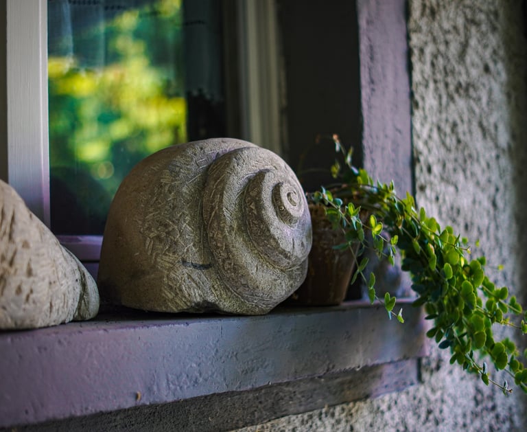 Schneckenhaus aus Naturstein auf einer Fensterbank