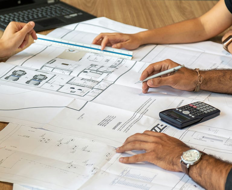 a group of people sitting at a table with papers and calculator