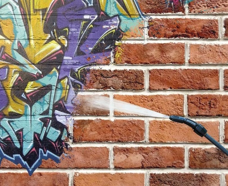 Graffiti being removed from brick wall, in toronto