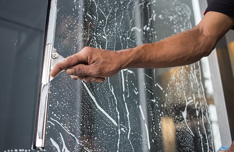 Man cleaning window with squeegee in Toronto