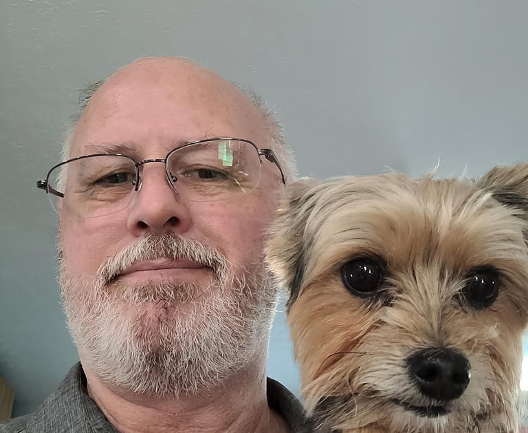 a man in a gray shirt is holding a dog