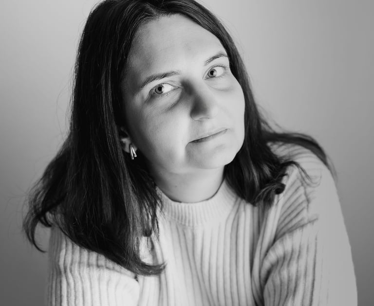 a woman with a white sweater looking towards the camera smiling