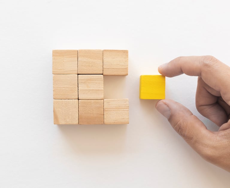 Hand pushes last piece of wood block to complete shape