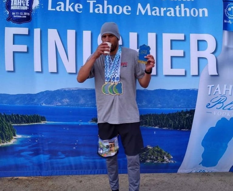 Ray Z aka Ray Z Unstoppable at the finish of the Lake Tahoe Triple Marathon with medals