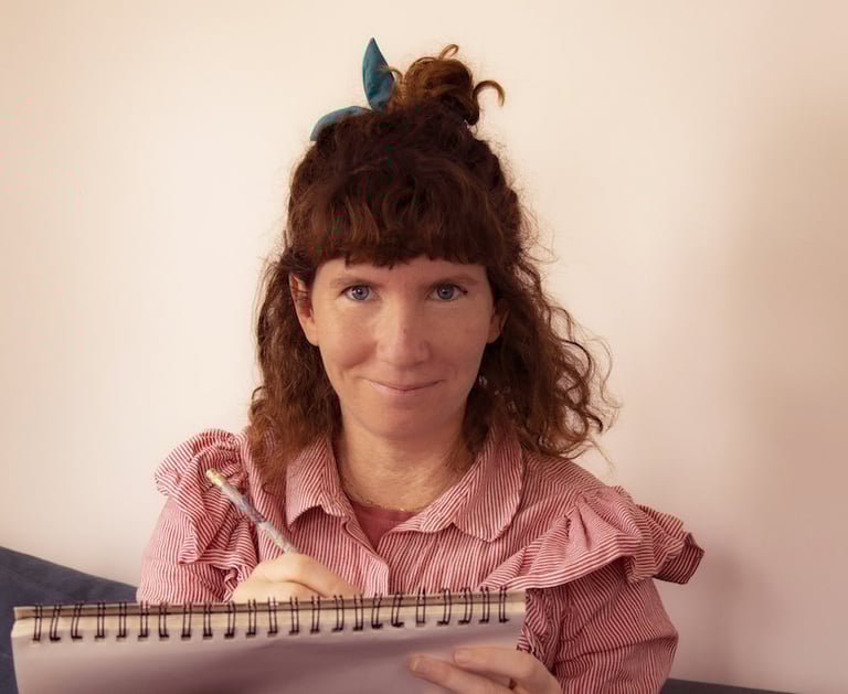 Photographie portrait d'Oriane Marie tenant un carnet et un crayon.