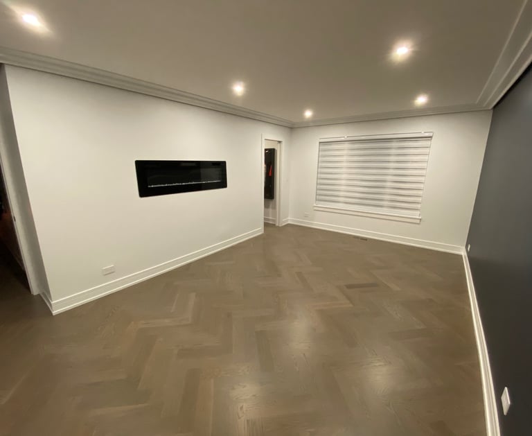 Custom herringbone hardwood flooring installation with modern fireplace in a Chicago North Shore home