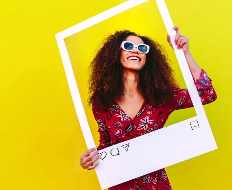 Woman wearing designer frames and holding up a social media post