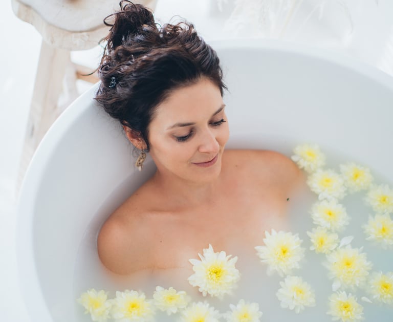 a woman in a bathtub with flowers in the tub