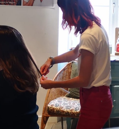 a woman is cutting a woman's hair