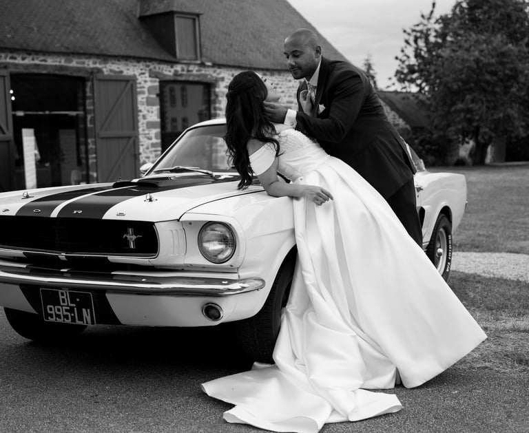 Deux mariés posant sur une ford mustang