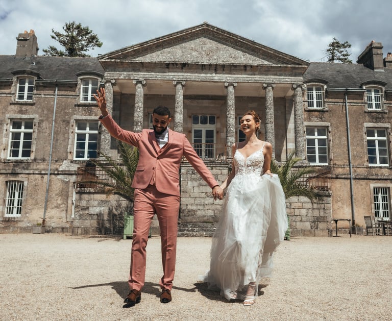  La mariée et le marié heureux marchent ensemble devant un grand édifice.