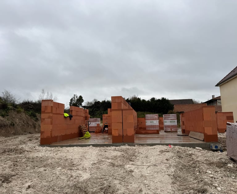 Murs en briques d'argile rouge en cours de construction sur des fondations en béton sur un nouveau c