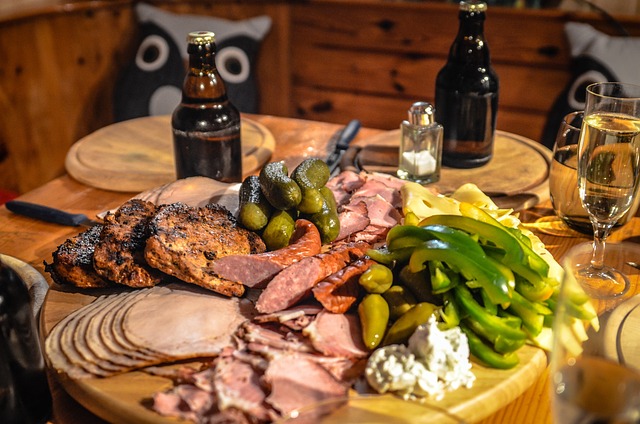 Una mesa de madera llena de comida y dos botellas de cerveza