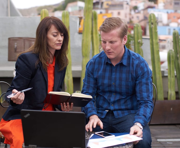 a man and woman sitting on a bench in a city