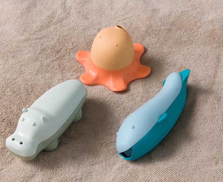 Three bath toys - blue whale, orange octopus and grey hippopotamus