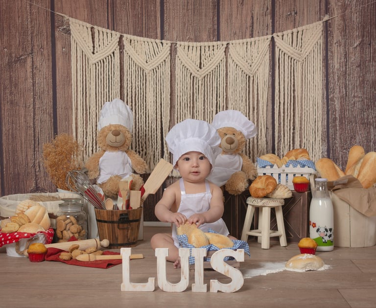 a baby in a chef hat and a teddy bear