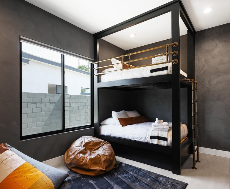 Soft gray limewash accent wall in a bedroom, creating a textured, organic finish for a modern and co