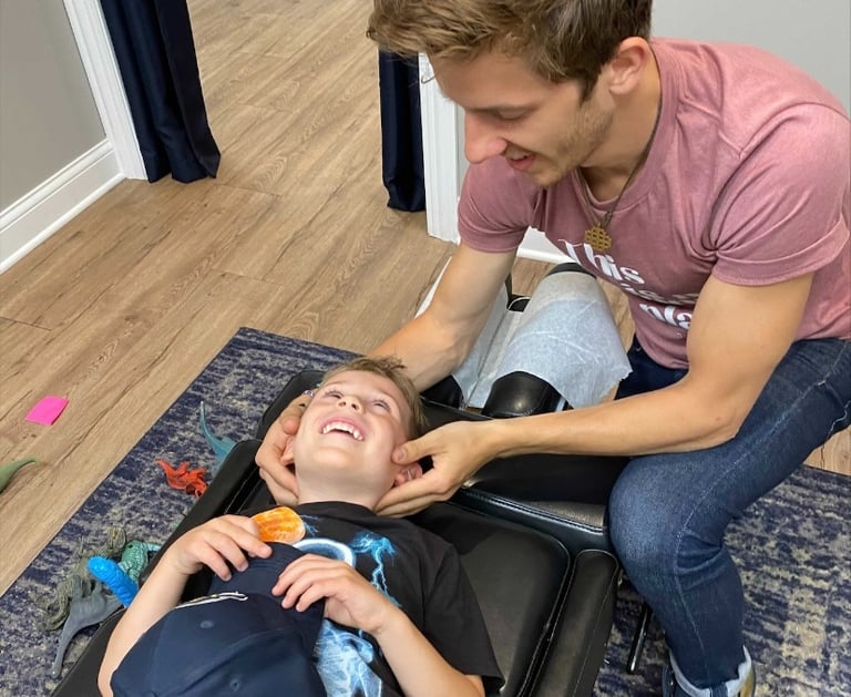 Happy child getting adjusted to help calm their nervous system to sleep better in Franklin, TN
