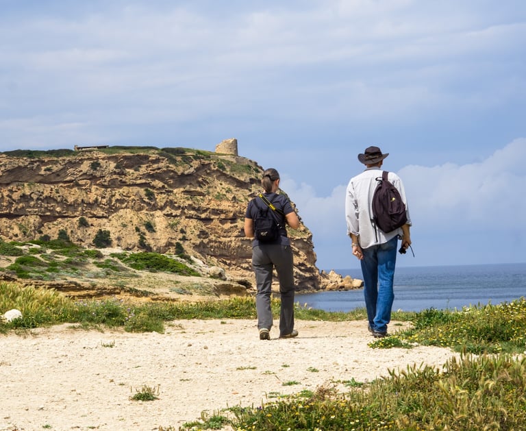 Two tourists walking to Capo Mannu tower, Sinis Peninsula Sardinia