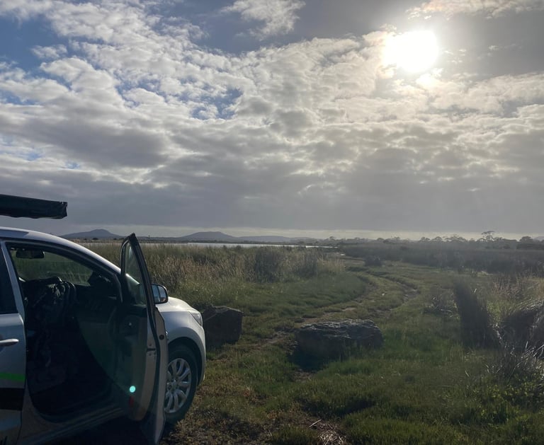 parking spot next to meadow and lake with sunshine through the clouds
