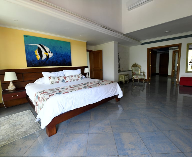 a bedroom with a bed and a painting on the wall