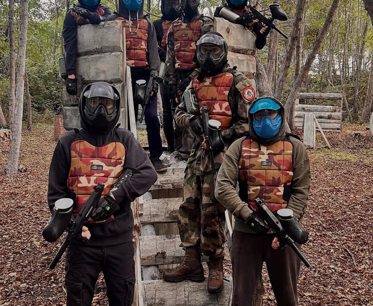 Groupe de joueurs équipés en tenue de paintball sur terrain boisé à Anghione en Corse 