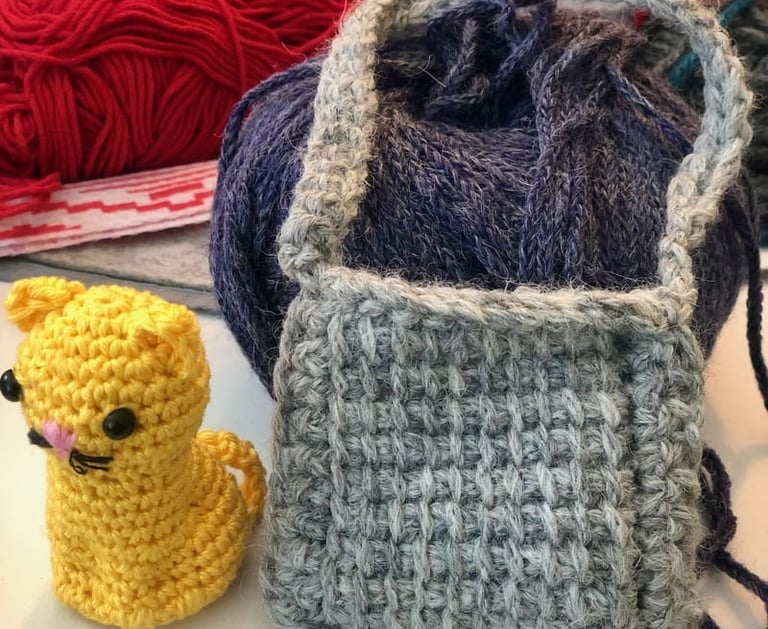 Figura de gato amarillo tejida a crochet, hecha a mano, un bolso gris tejido en crochet tunecino