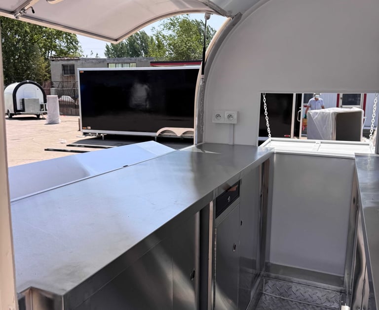 Intérieur du foodtruck demi-rond TF-DM Classic, plan de travail et rangements en acier inoxydable, sol aluminium antidérapant
