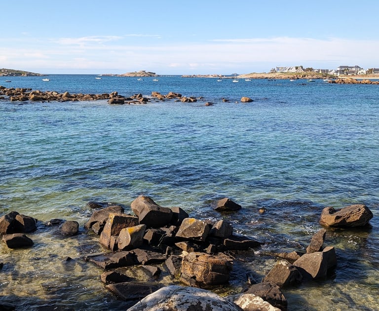 bord de mer, Eau cristalline, rochers et îlots sous un ciel bleu, offrant un paysage côtier apaisant