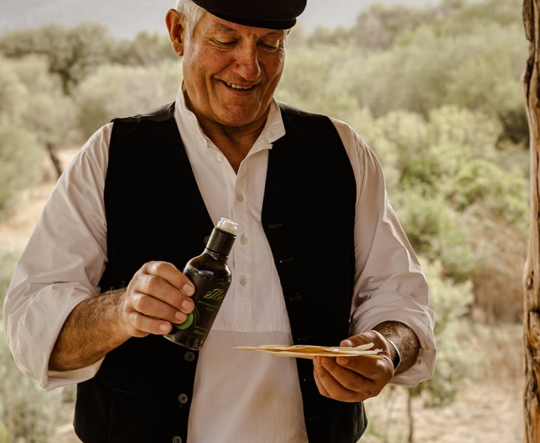 Man in traditional dress pouring olive oil on pane carasau, Sardinia