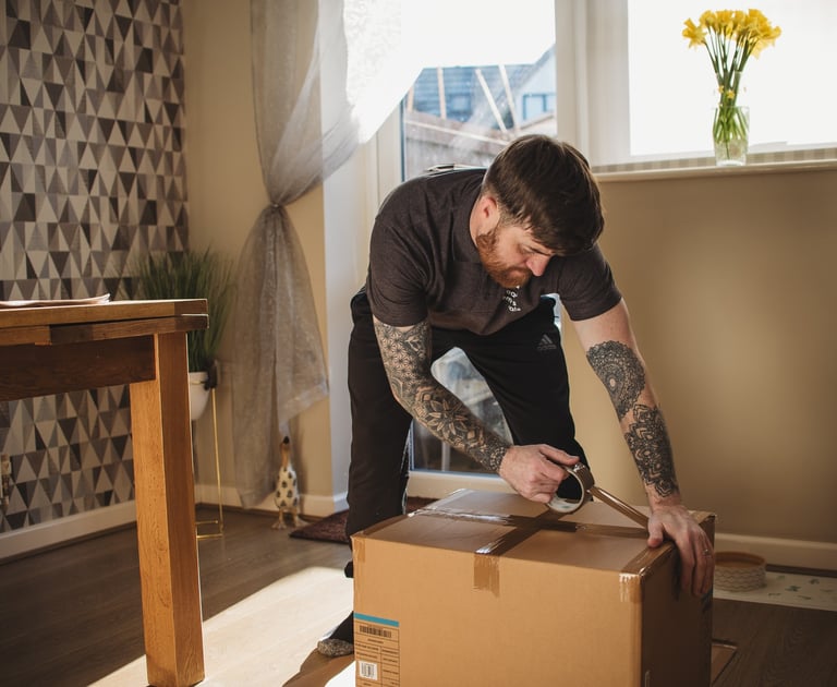 dean from deanos removals taping up a box in a worcestershire home