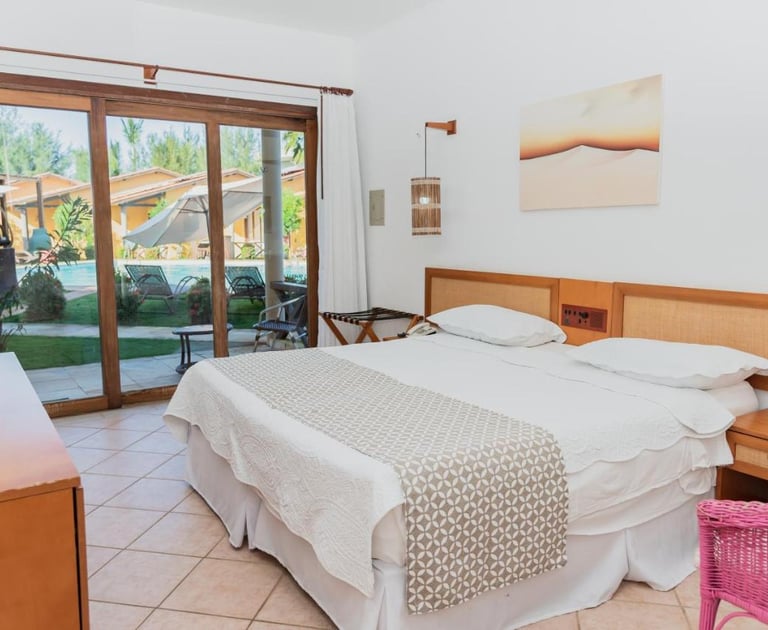 quarto com cama, luminarias e vista para o jardim