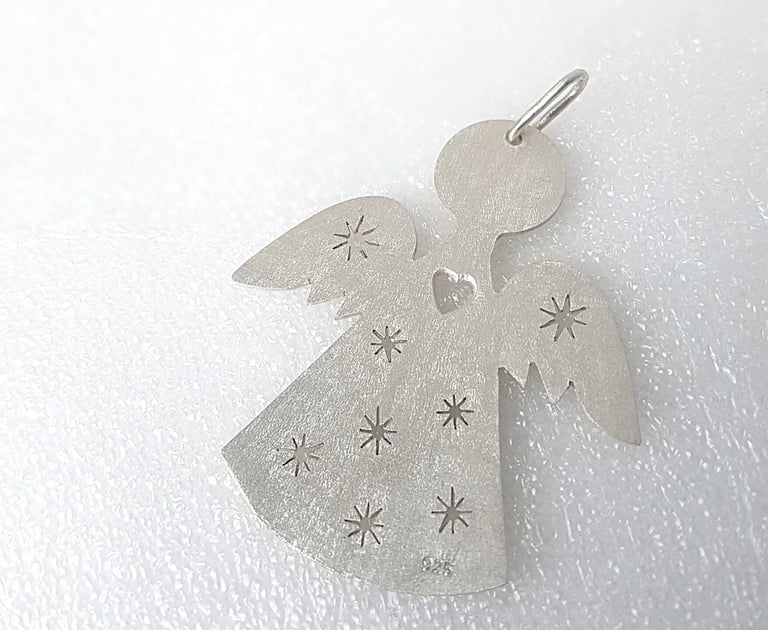 a silver angel with stars on a white surface