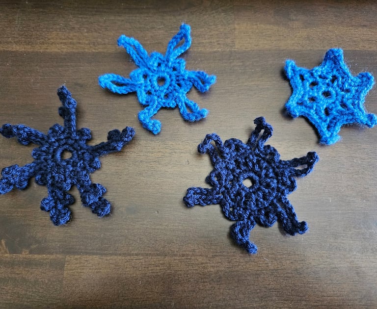 blue crochet snowflakes on a wooden table