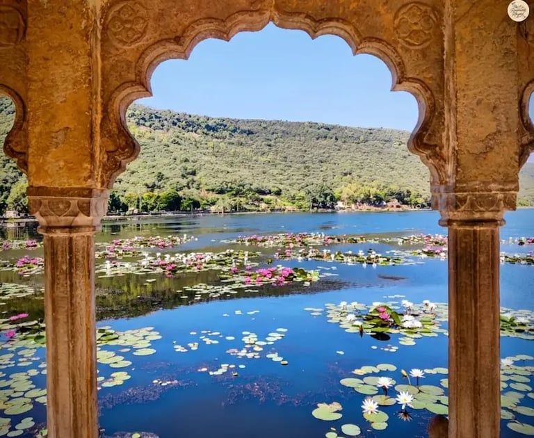 View of Jait Sagar Lake framed through the ornate arches of Sukh Mahal in Bundi.